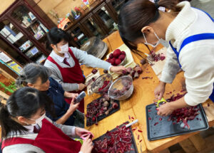 People from 0100 Community Circle and Karatsu Minami High School students are preparing the ingredients for borsch in Quanne cafe.